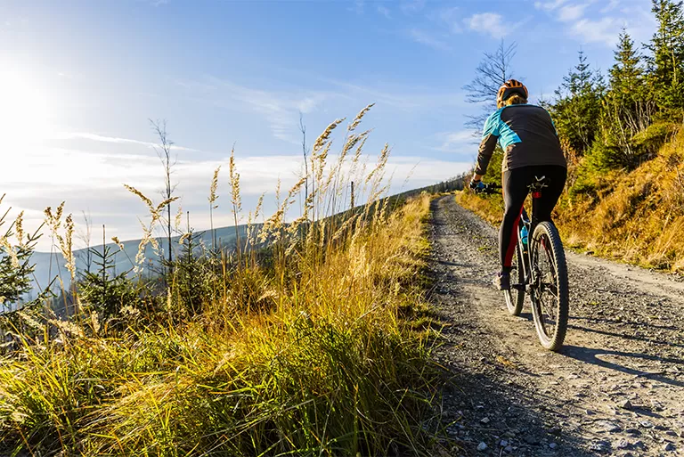 A woman biking in Mountain Village, CO one of the many activities you can do when you rent a luxury cabin or condo from SilverStar Telluride